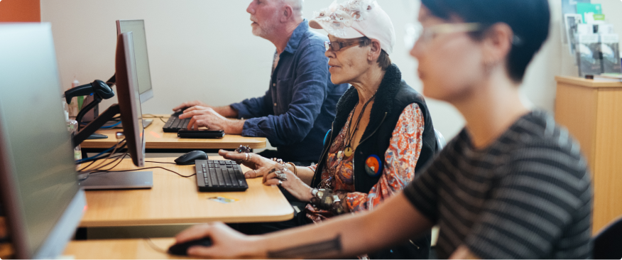 Three people learning at library computers