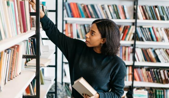 Women placing book on a shelf