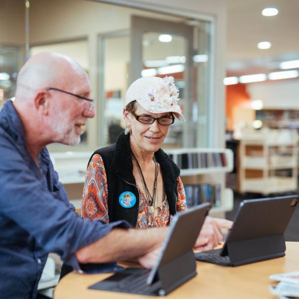 Man & women working on a computer at the library