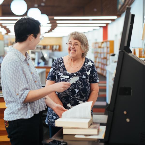 Two women borrowing library books