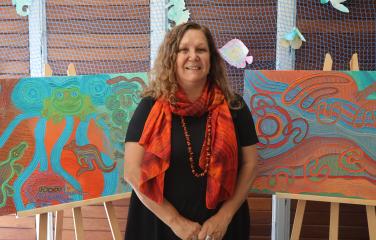 Saretta Fielding standing in front of her library card artwork