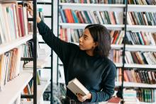 Women placing book on a shelf